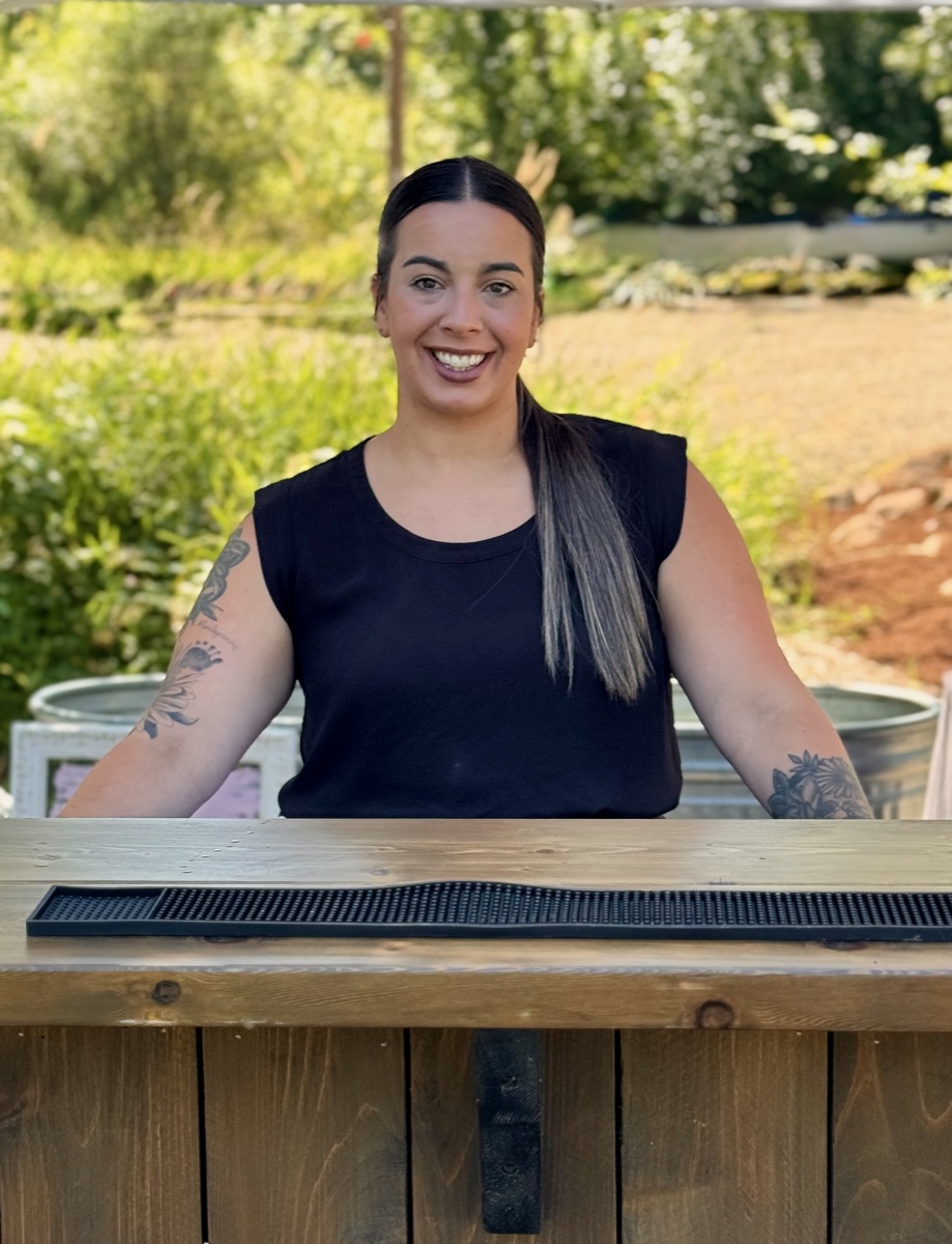 Riley Challenger — founder of Hustle & Bustle Coordination, warm professional portrait in a Pacific Northwest garden
