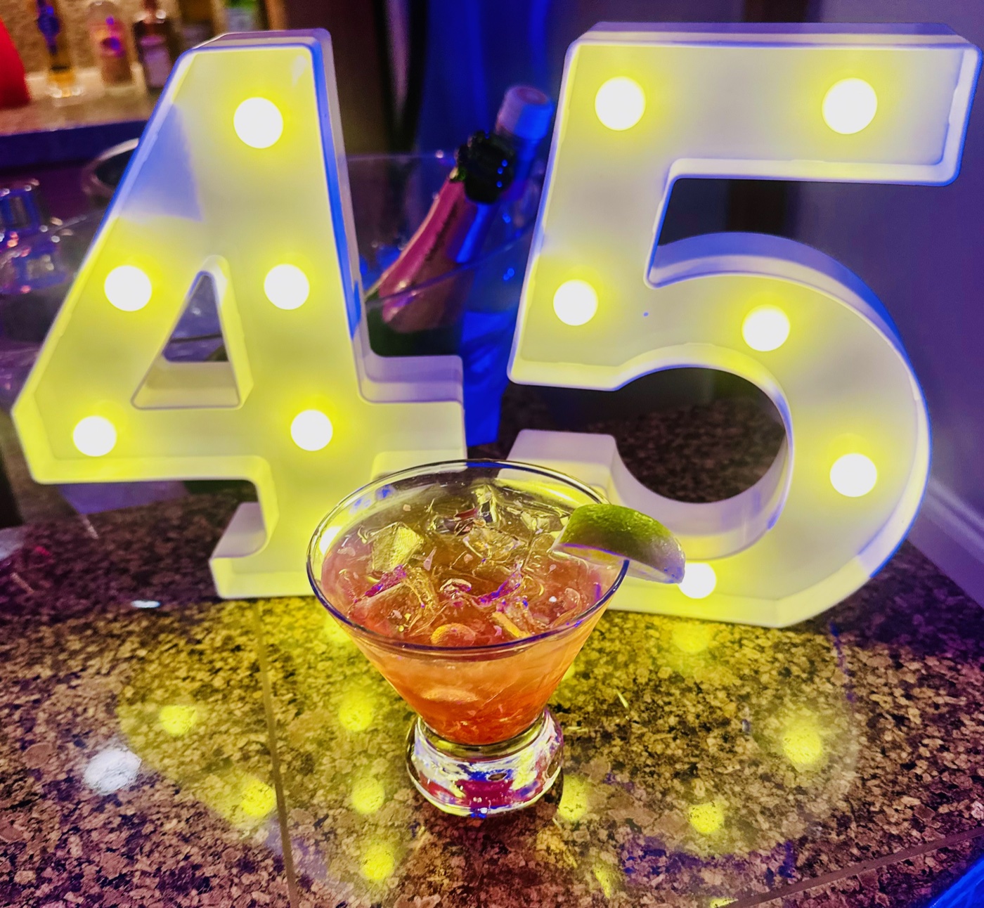 Signature cocktail with light-up 45 sign at a 45th birthday party